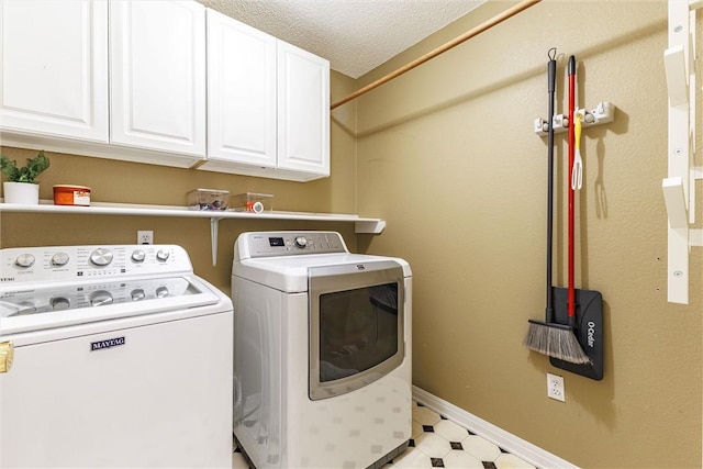 laundry room with light floors, baseboards, cabinet space, separate washer and dryer, and a textured ceiling