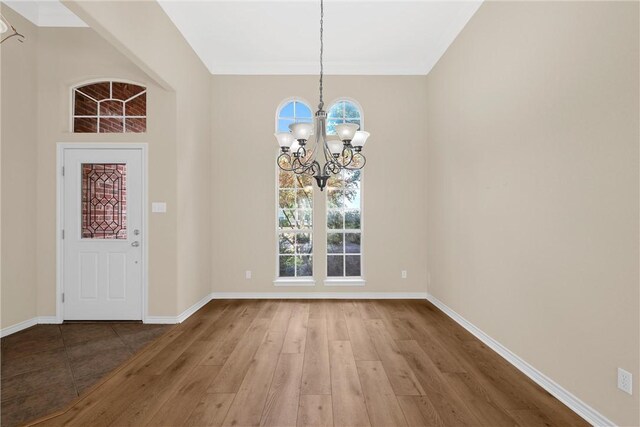 foyer entrance with an inviting chandelier and hardwood / wood-style flooring