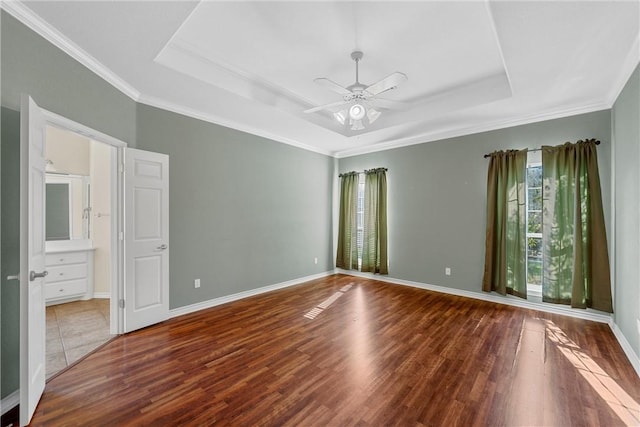 spare room with hardwood / wood-style floors, a raised ceiling, ceiling fan, and ornamental molding