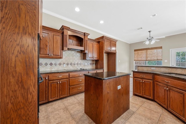 kitchen with a kitchen island, backsplash, dark stone counters, light tile patterned flooring, and ornamental molding