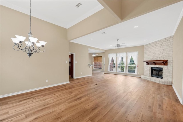 unfurnished living room featuring a fireplace, ornamental molding, ceiling fan with notable chandelier, and light wood-type flooring