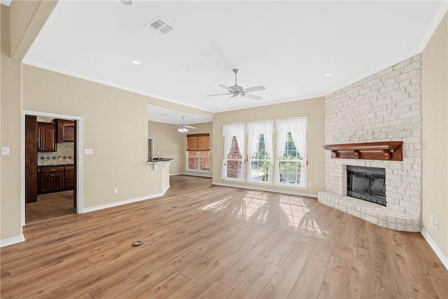 unfurnished living room with a brick fireplace, light hardwood / wood-style flooring, ceiling fan, and crown molding