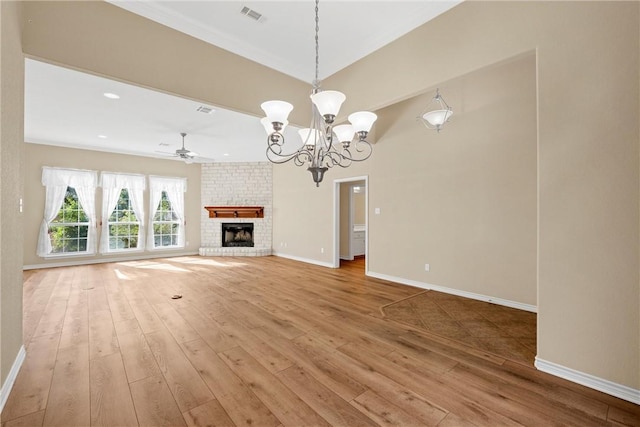 unfurnished living room featuring a fireplace, hardwood / wood-style floors, and ceiling fan with notable chandelier