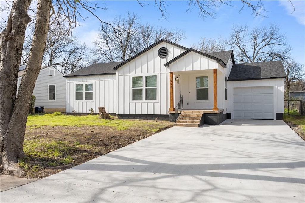 modern farmhouse style home with covered porch, board and batten siding, concrete driveway, and a shingled roof