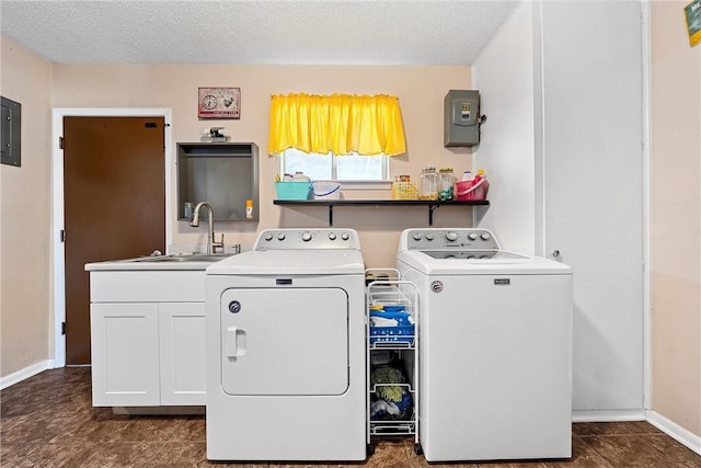 washroom featuring a textured ceiling, washing machine and dryer, cabinets, and sink