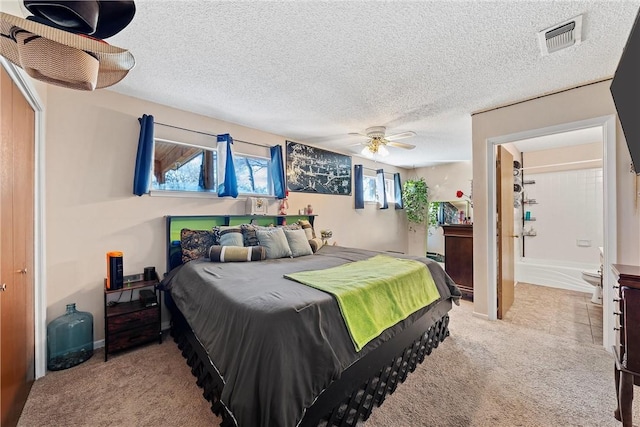 bedroom with a textured ceiling, light colored carpet, and ceiling fan