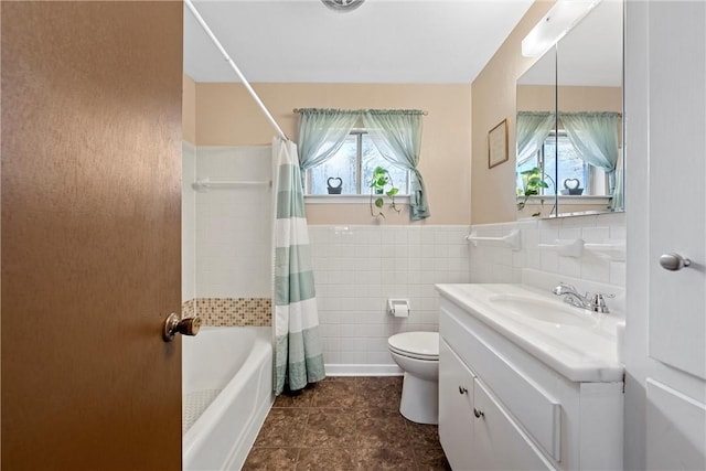 full bathroom with vanity, plenty of natural light, shower / bathtub combination with curtain, and tile walls