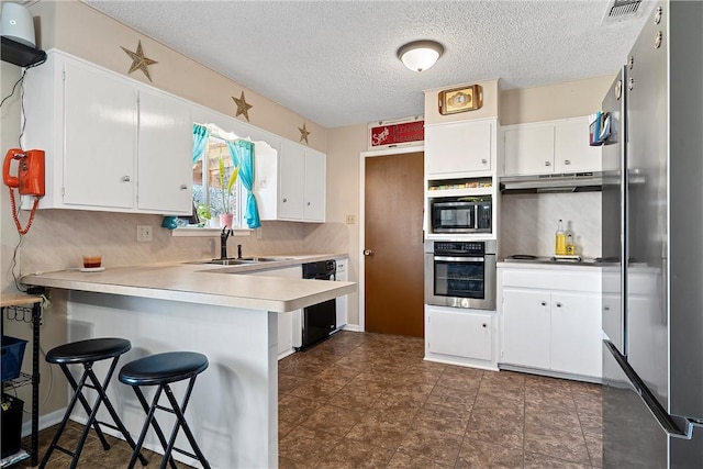 kitchen featuring kitchen peninsula, white cabinetry, and black appliances