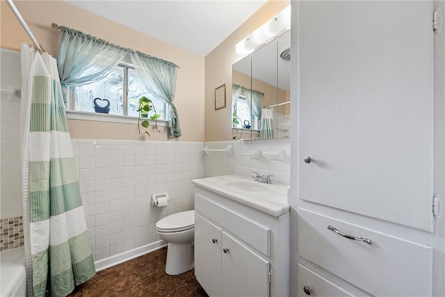 full bathroom featuring vanity, toilet, tile walls, and a wealth of natural light