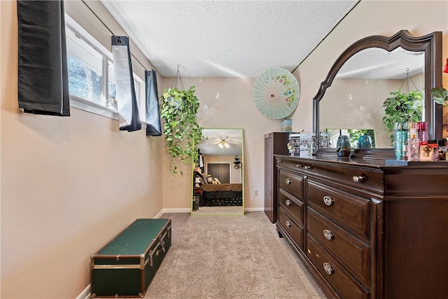 hall with light carpet and a textured ceiling