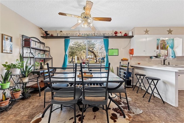 dining room with a textured ceiling, ceiling fan, and sink