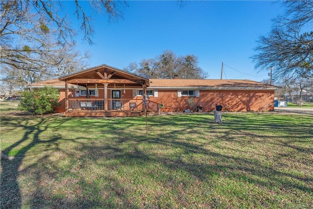 rear view of property featuring a lawn