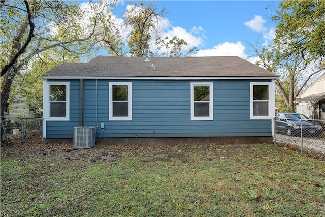 rear view of house with a lawn and cooling unit