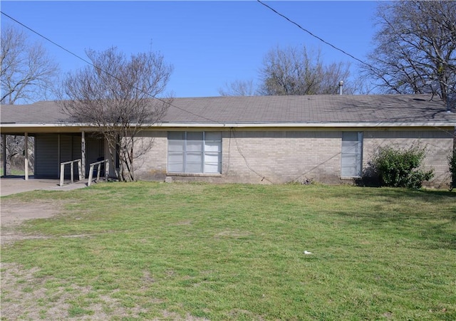 rear view of property featuring brick siding and a lawn