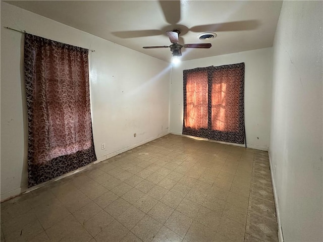 unfurnished room featuring baseboards, a ceiling fan, visible vents, and tile patterned floors