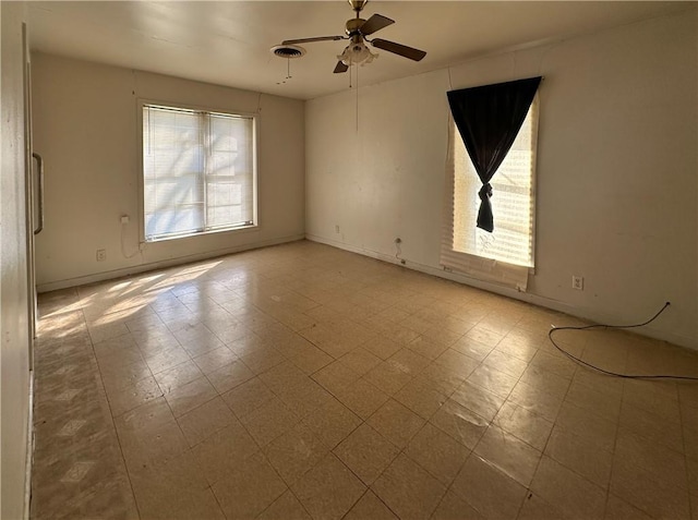 unfurnished room with a ceiling fan, baseboards, and tile patterned floors