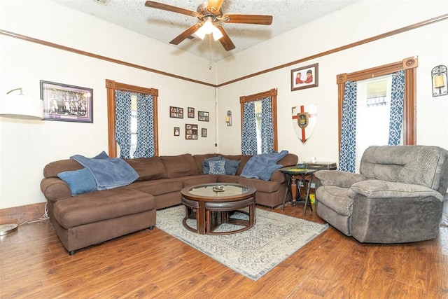 living room with ceiling fan, wood-type flooring, and a textured ceiling