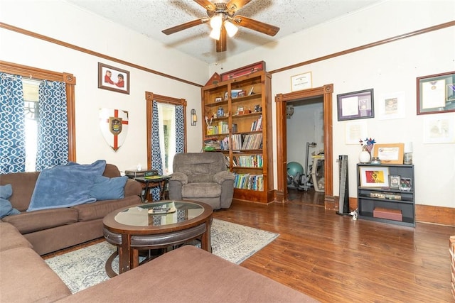 living room featuring ceiling fan, dark hardwood / wood-style floors, and a textured ceiling