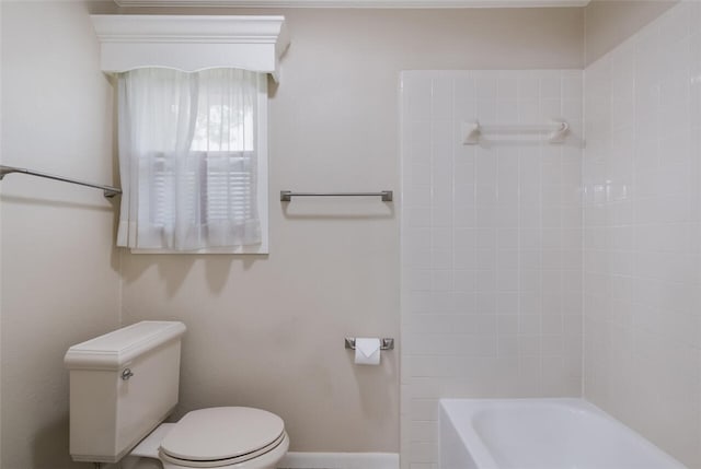 bathroom featuring tiled shower / bath combo and toilet