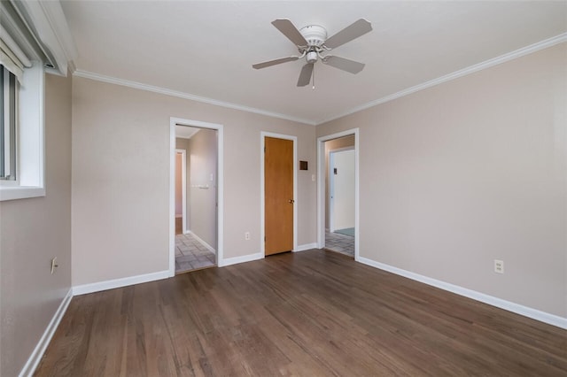 unfurnished bedroom featuring ceiling fan, crown molding, dark wood-type flooring, and ensuite bath