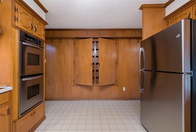 kitchen with ornamental molding, stainless steel appliances, and wooden walls