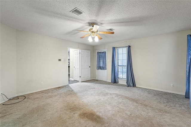 carpeted empty room with ceiling fan and a textured ceiling