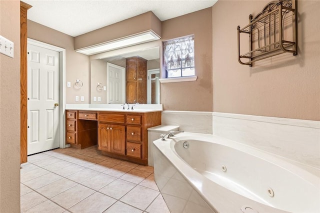 bathroom featuring tiled bath, tile patterned flooring, and vanity