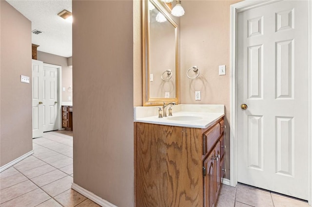 bathroom featuring tile patterned floors, vanity, and a textured ceiling