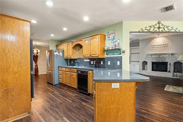 kitchen featuring stainless steel refrigerator, dishwasher, dark hardwood / wood-style flooring, decorative backsplash, and a fireplace