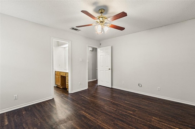 unfurnished bedroom featuring a textured ceiling, dark hardwood / wood-style flooring, ensuite bath, and ceiling fan