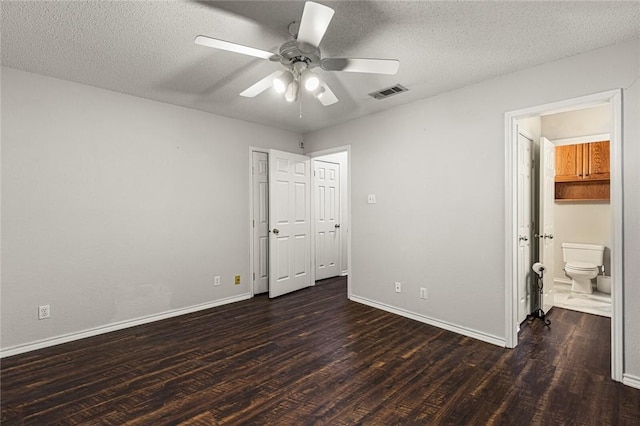 unfurnished bedroom featuring a textured ceiling, ensuite bath, ceiling fan, and dark hardwood / wood-style floors