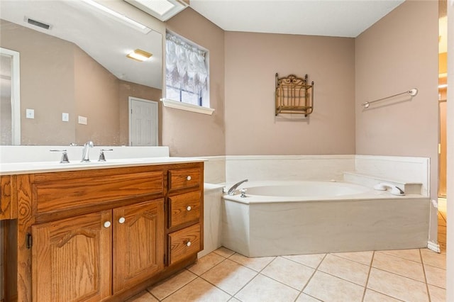 bathroom with a bathing tub, tile patterned flooring, and vanity