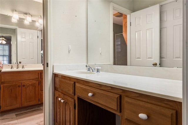 bathroom featuring wood-type flooring, vanity, and ceiling fan