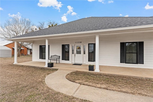 rear view of house with covered porch and a yard