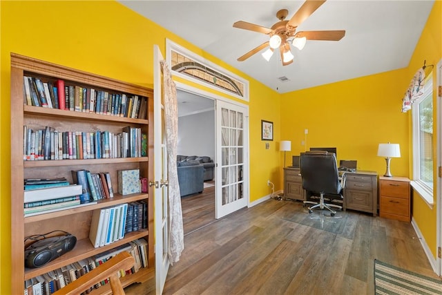 home office featuring dark wood-type flooring, ceiling fan, and french doors