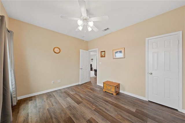 empty room featuring ceiling fan and dark wood-type flooring