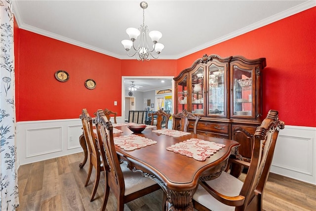 dining area featuring hardwood / wood-style flooring, ornamental molding, and a notable chandelier