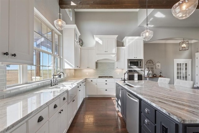 kitchen featuring a center island, appliances with stainless steel finishes, decorative light fixtures, dark hardwood / wood-style flooring, and white cabinetry