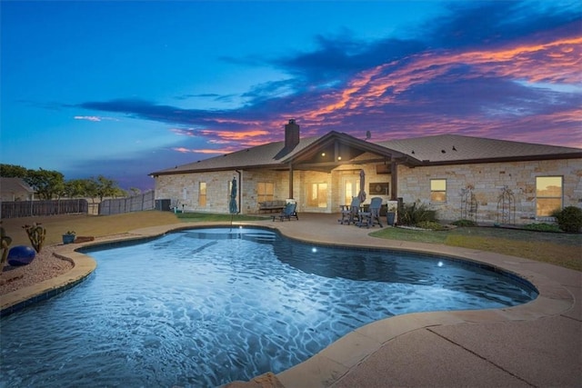 pool at dusk with a patio