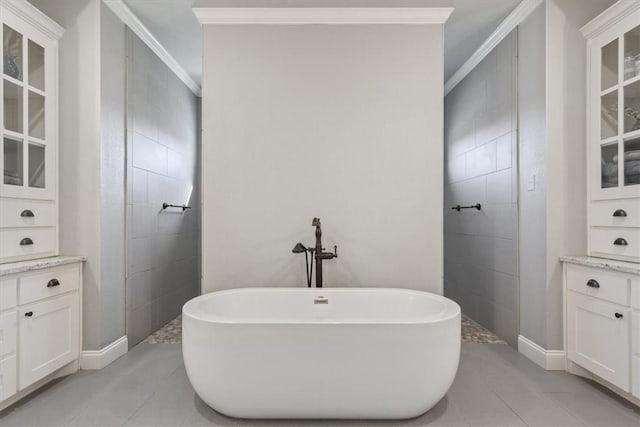 bathroom featuring tile patterned flooring, vanity, ornamental molding, and a bath