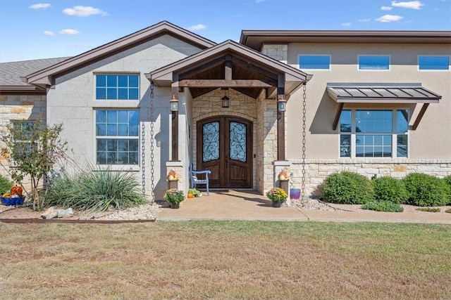 entrance to property featuring a lawn and french doors