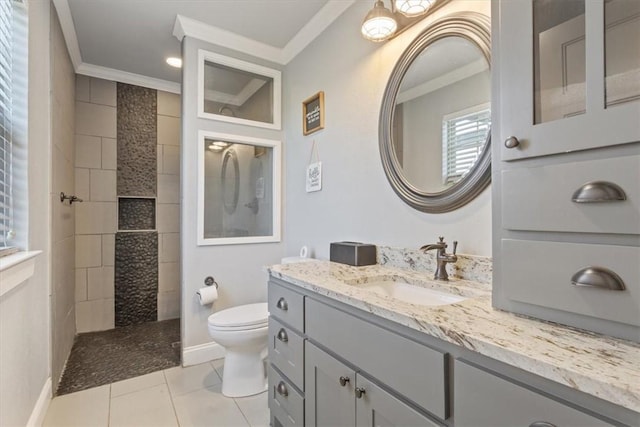 bathroom with tile patterned floors, a tile shower, vanity, crown molding, and toilet