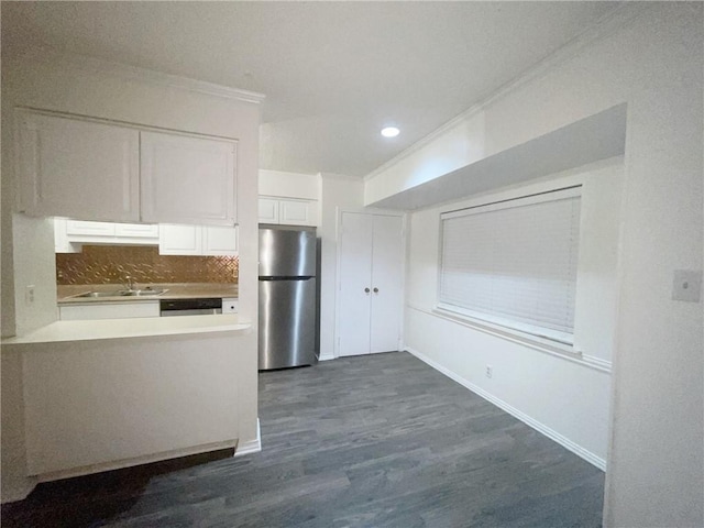 kitchen featuring decorative backsplash, dark hardwood / wood-style flooring, stainless steel appliances, sink, and white cabinetry