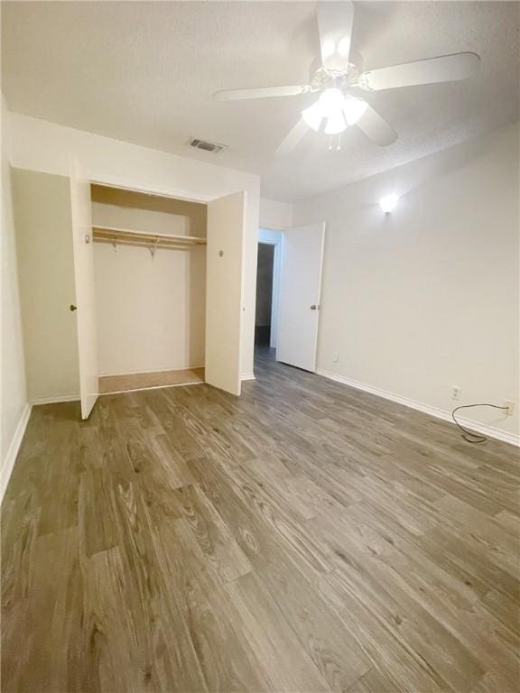 unfurnished bedroom featuring a closet, ceiling fan, and hardwood / wood-style flooring