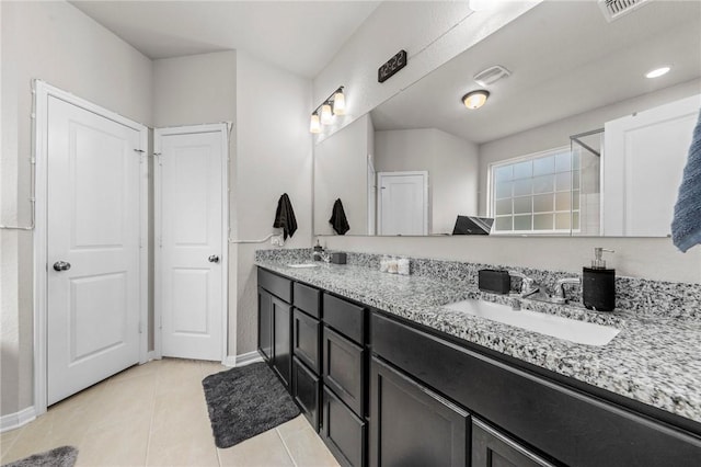 bathroom featuring tile patterned flooring, a sink, baseboards, and double vanity