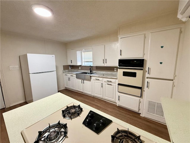 kitchen featuring white cabinetry, white appliances, sink, and dark wood-type flooring