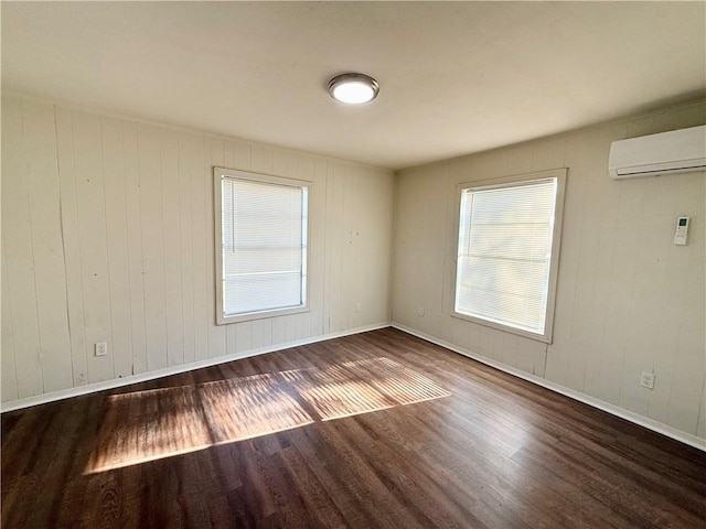 empty room featuring a wall mounted AC, wood walls, and dark wood-type flooring