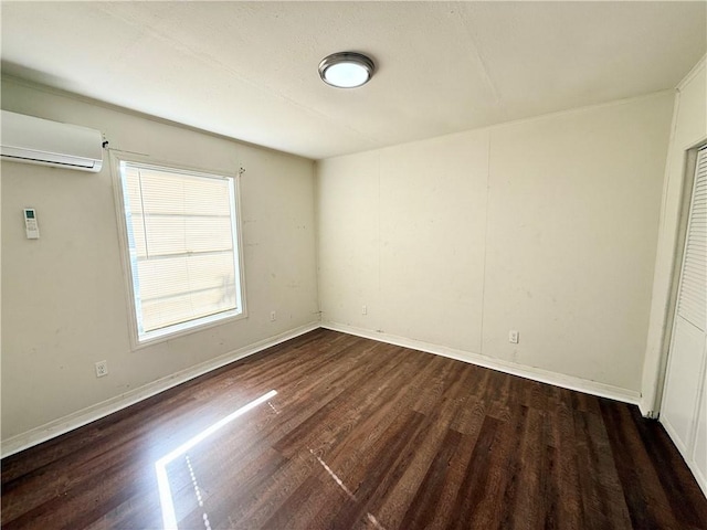 unfurnished room with dark hardwood / wood-style flooring and a wall mounted AC