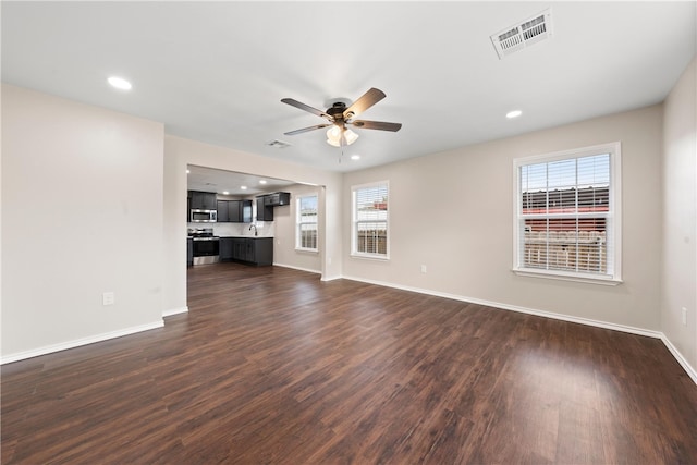 unfurnished living room featuring sink, dark hardwood / wood-style floors, and ceiling fan