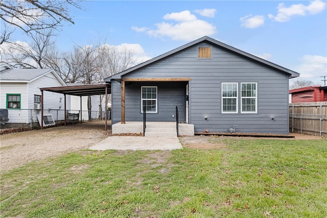 rear view of property with a carport and a lawn